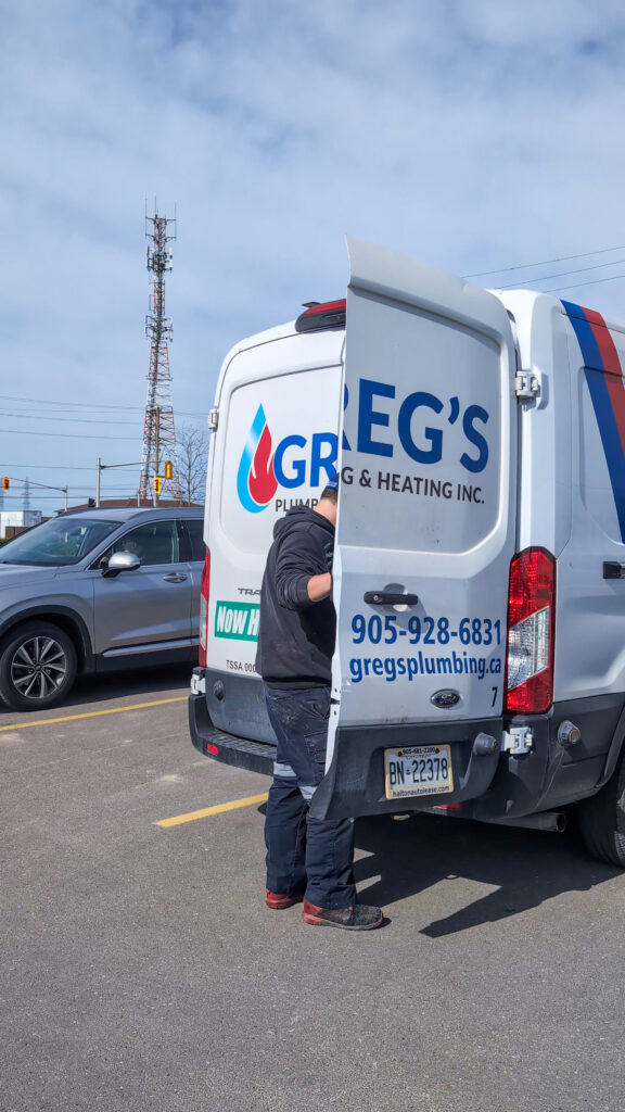 Greg’s Plumbing and Heating technician standing beside service van