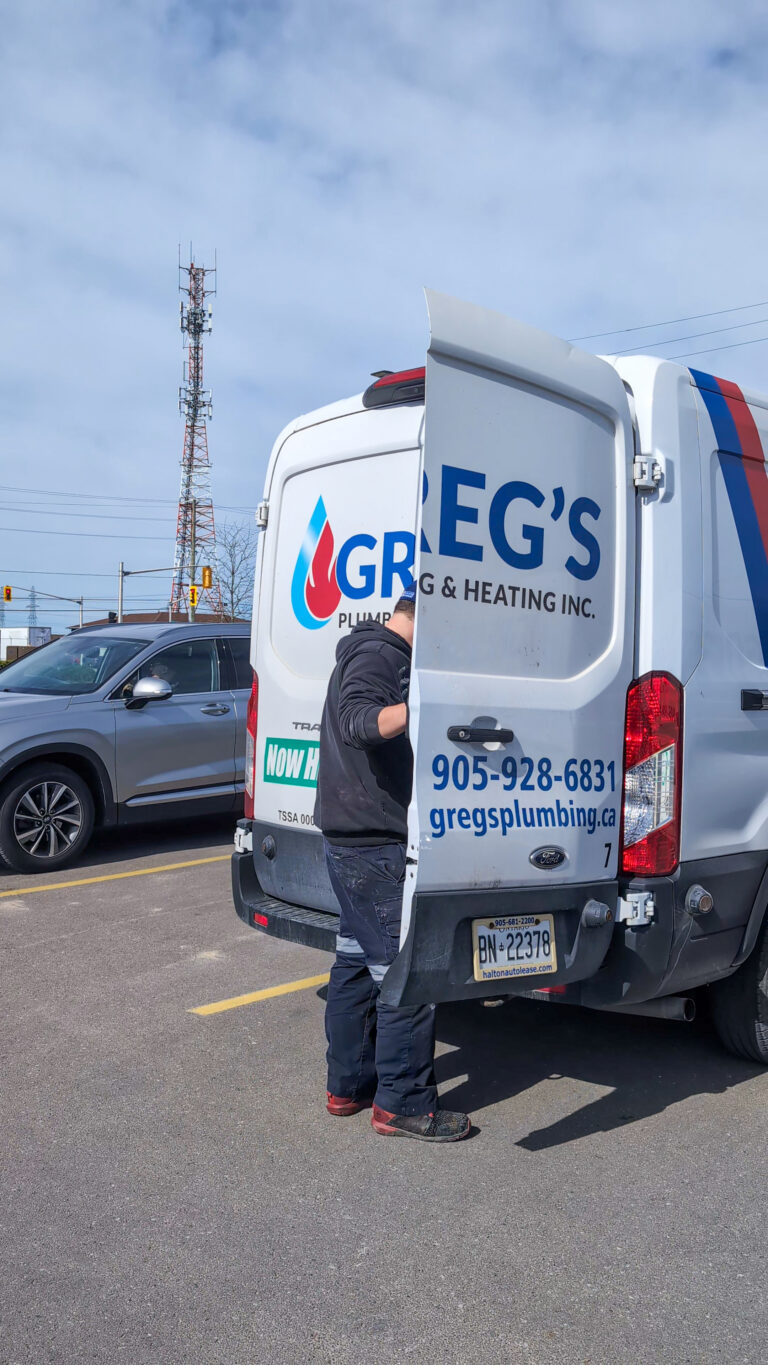 Greg’s Plumbing and Heating technician standing beside service van